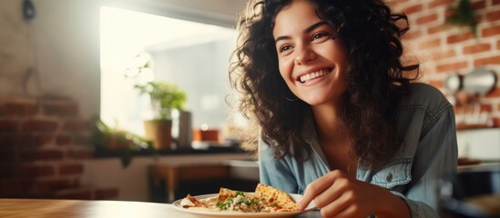 Satisfied Hispanic woman happily enjoying pizza at home.