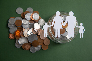 Wall Mural - Paper family with a coins on the green background.