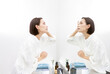 不安な表情で鏡を見ながら肌を触るミドル世代女性