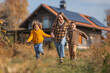 Happy family against the background of a house with installed solar panels. Alternative energy, resource saving and sustainable lifestyle concept.Green energy concept.Place for text.Copy space.