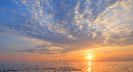 Wall Mural - Evening sky with golden sunlight and dramatic clouds over sea at sunset time, Idyllic tropical horizontal seascape, Natural peaceful sunrise sky background in the morning