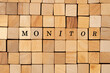 a large number of wooden cubes with the inscription monitor in black letters, creative concept