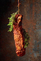 Wall Mural - Smoked pork ribs with juniper branches on a rusty background.