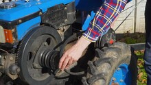 Man Puts A Belt On The Motor Pulley Of The Walk-behind Tractor, A Farmer Installs A Belt On A Walk-behind Tractor