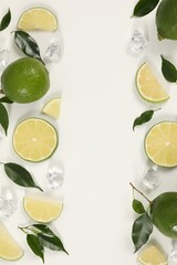 Wall Mural - Limes, ice and green leaves on white background, flat lay. Frame with space for text