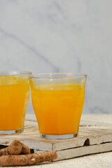 indonesian traditional herbal drink for women.jamu kunyit asam  with the basic ingredients of turmeric and tamarind and other herbs.heaps of turmeric in a bamboo basket as a background