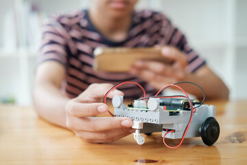 asian teenager doing robot project in science classroom. technology of robotics programing and stem 
