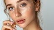 © xartproduction - Caucasian young blond woman puts skin care serum on her cheek