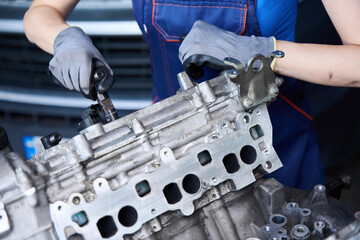 Auto mechanic at the workplace works with large auto part