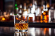 © serperm73 - A decanter of whiskey and a glass on a mirrored bar against the background of bottles of alcohol in a bar. AI generated.
