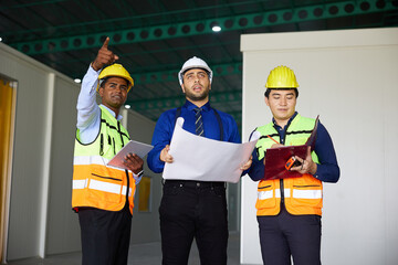 workers or engineers planning from work on blueprint drawing paper in the factory