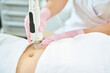 Cropped of female cosmetologist doing microneedle rf lifting of woman belly skin