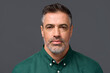 Confident middle aged business man entrepreneur, unsmiling mature professional executive manager, businessman leader investor wearing green shirt isolated on gray, headshot close up portrait.