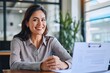 Smiling professional Latin employer hr manager holding cv during interview hiring for job female Asian female recruit, advisor consulting client sitting in office at meeting. HR, Generative AI