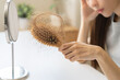 Stress asian young woman, girl hand holding comb show her hairbrush with loss, hair in brush after brushing, hair fall out problem. Health care, beauty with treatment concept, isolated on background.