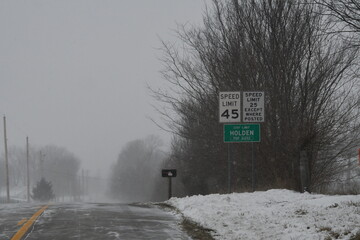 Poster - Road Signs by a Snowy Highway