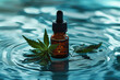 A dropper bottle, possibly with hemp oil, rests on a rippling water-like surface. Four cannabis-like green leaves frame it. Blue, refreshing background