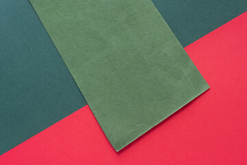 Sticker - textured green paper rectangle diagonally on dark green and red paper