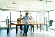 © AntonioDiaz - Full length view of a Latin man dancing and celebrating after getting a job promotion at work