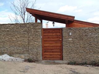 stone fence with wooden fence panels