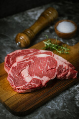 Wall Mural - raw ribeye steak meat on black marble background