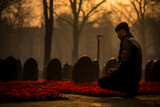 Fototapeta Morze - A man sitting on a grave in a cemetery at sunrise with red flowers.