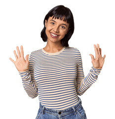 Wall Mural - Young Hispanic woman with short black hair in studio showing number ten with hands.