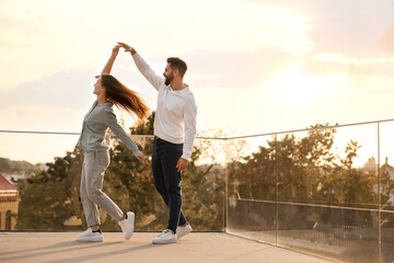 Lovely couple dancing together outdoors at sunset, space for text