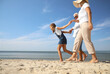 © New Africa - Cute little girl with grandparents spending time together on sea beach