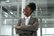 © New Africa - Happy woman with crossed arms in office, low angle view. Lawyer, businesswoman, accountant or manager