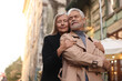 © New Africa - Portrait of affectionate senior couple on city street, low angle view. Space for text