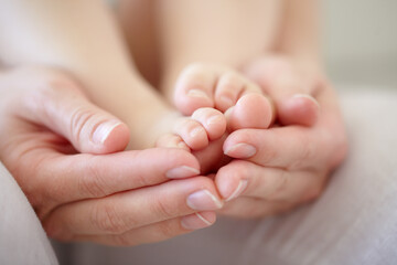 love, mother and hands with baby or feet for development, nurture and bonding in nursery of apartmen