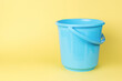 © kvladimirv - A blue plastic bucket on a yellow background.