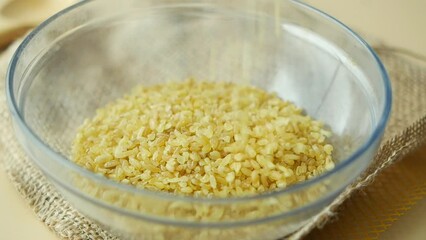 Wall Mural - slow motion of pouring Raw Bulgur Rice in a bowl 