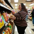 overweight woman buying sweets in the supermarket