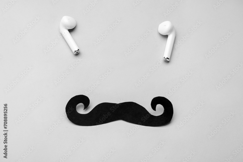 Black paper mustache and earphones on grey background