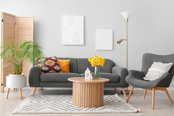 Interior of modern living room with cozy sofa, armchair and coffee table