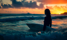 Silhouette Of Female Surfer With Board At Sunset.
