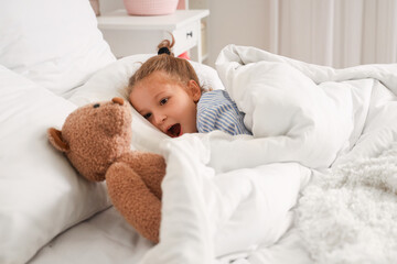 Poster - Cute little girl with toy bear lying in bed