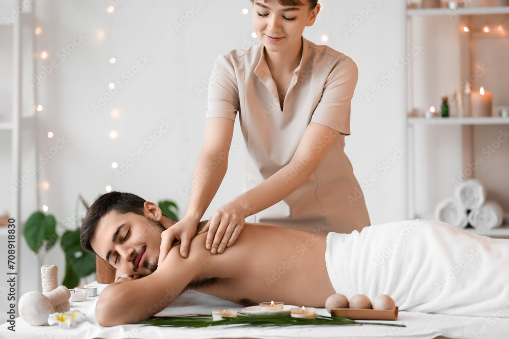 Young man getting massage in spa salon