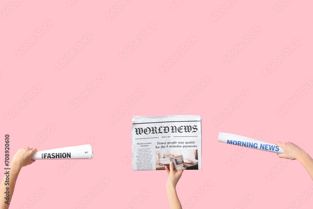 Women with newspapers on pink background