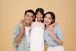 © NaMong Productions - Portrait happy smiling Asian family hugging and love together isolated on nude color background.
