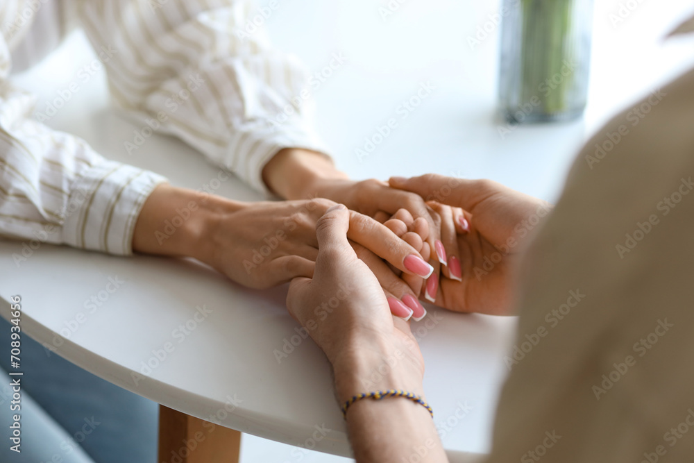 Woman and man holding hands at table in kitchen