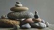  a pile of rocks stacked on top of each other on top of a rock covered ground with a gray wall in the background and a gray wall in the background.