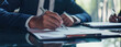 © Ai Studio - A professional at work, signing documents with focus and determination, a representation of business formality and commitment