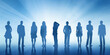 © zamuruev - Silhouettes of group of business people standing in line on sky blue background