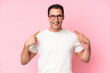 © luismolinero - Young caucasian man isolated on pink background giving a thumbs up gesture