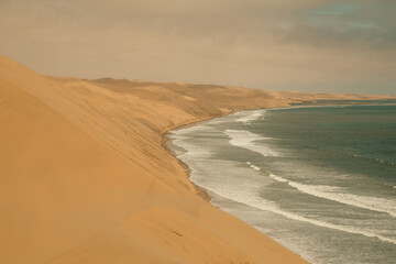 Wall Mural - Ocean meets the Sand dunes in Sandwich Harbour Historic, Namibia