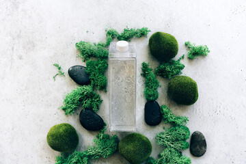 Bottle of water amidst moss and stones