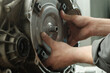 Repair of an automatic transmission at a car service station. The torque converter is in the hands of an auto mechanic. Assembly of an automatic transmission. Installing the torque converter.